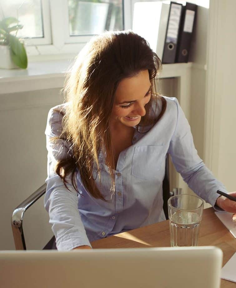 Adult learner sat at her desk using a laptop computer to work on the Roadmap MBA