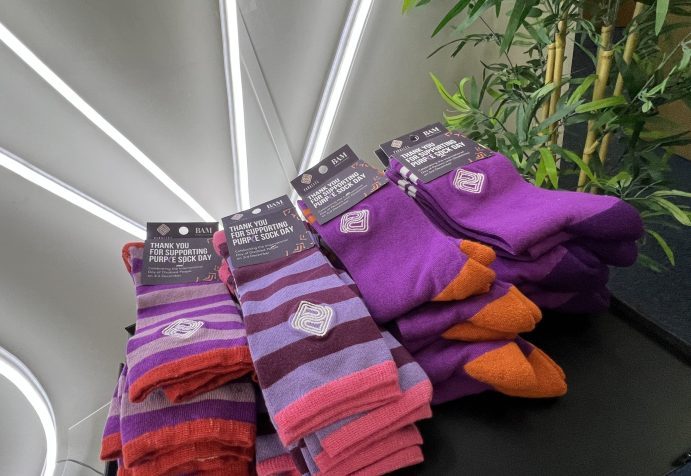 Roadmap MBA celebrating Purple Sock Day with 24 pairs of bright purple socks shown on a small black table