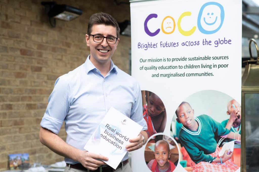 Photo of Roadmap MBA founder Steve Pugh holding a Roadmap MBA book in front of a COCO roller banner